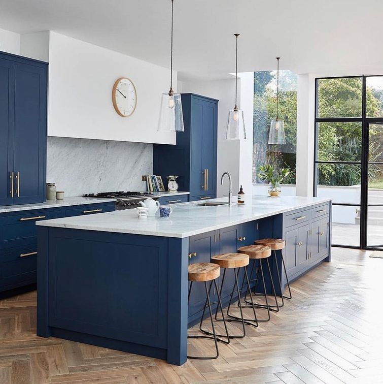 Blue shaker kitchen with gold hardware and herringbone floors