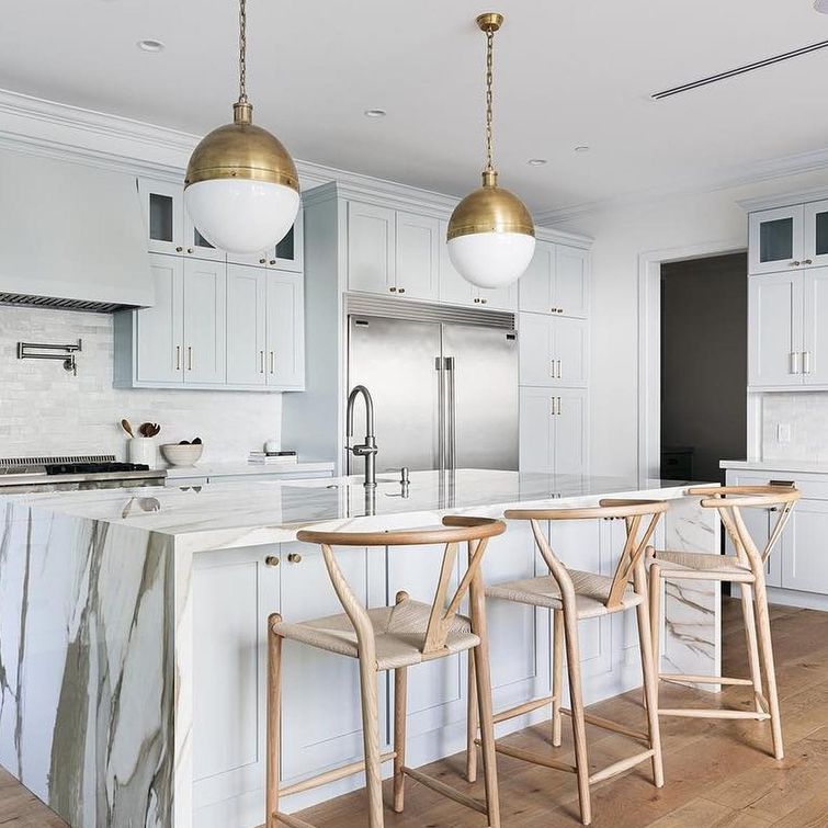 Contemporary kitchen with golden lighting and white cabinets