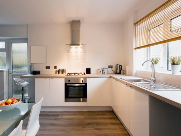Bright modern kitchen with clear white counters and a window over the sink